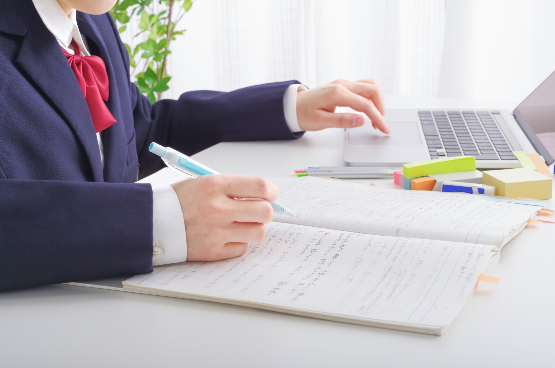 通信制高校の単位修得に向けてパソコンとノートを使って学習する高校生